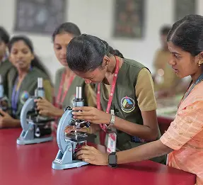 Students and a visitor at a field exhibition table